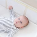 How should a baby sleep in a travel cot?